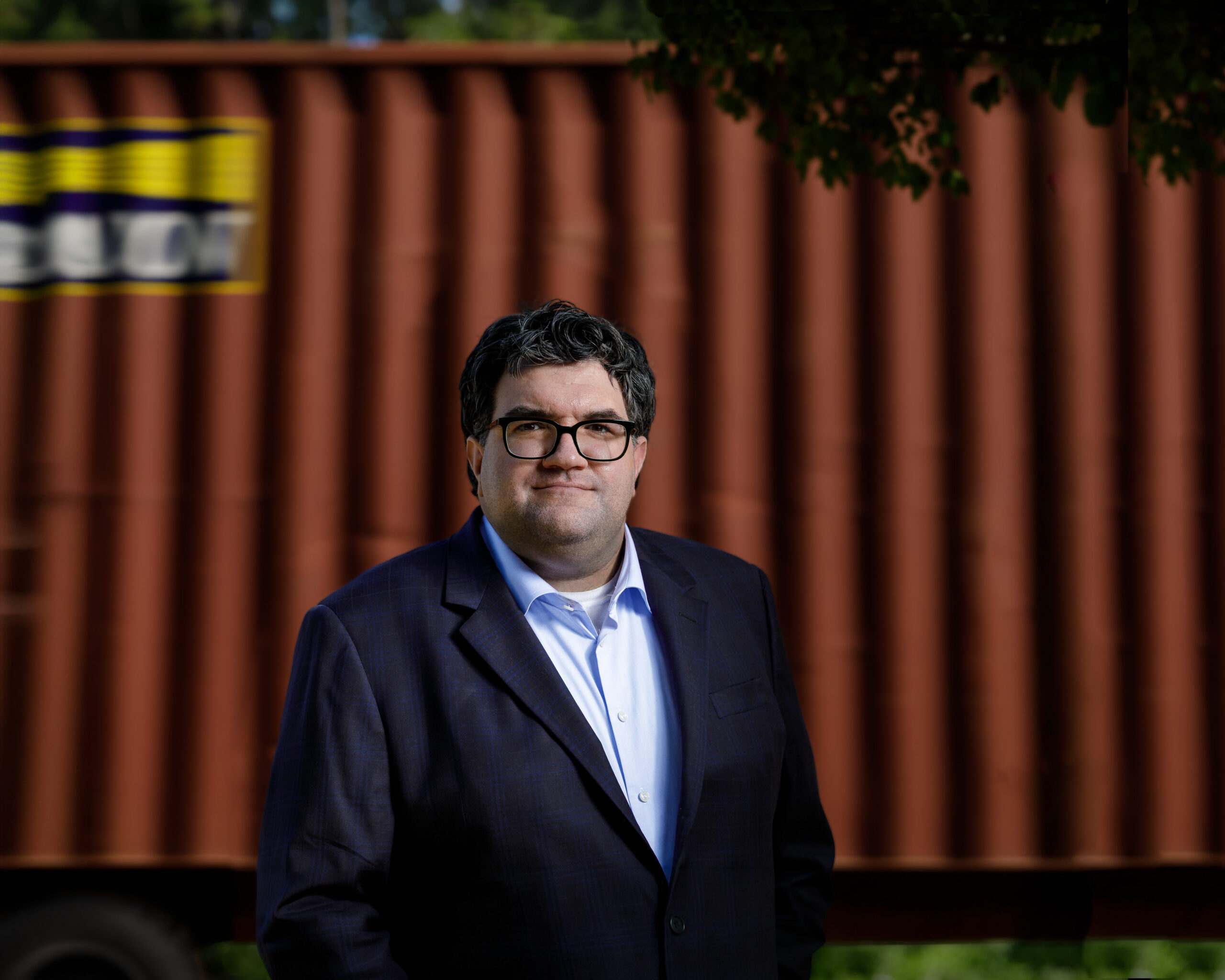 Chuck Giroux brand portrait beside shipping containers, Wando terminal Charleston SC